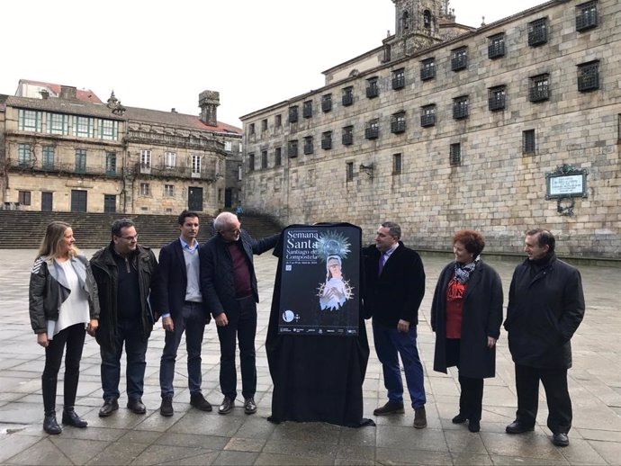 El concejal de turismo de Santiago, Gumersindo Guinarte, y el presidente de la Xunta de Cofradías, José Ramón Muñiz, destapan el cartel de la Semana Santa compostelana 2020