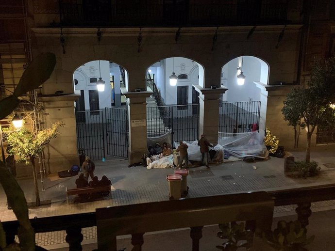 Imagen de varias personas durmiendo frente a las puertas de la sede del Samur Social.