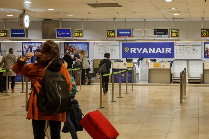 Varios pasajeros esperan para facturar su equipaje en los mostradores de la compañía Ryanair durante la operación salida de Navidad en el aeropuerto Adolfo Suárez Madrid-Barajas, en Madrid a 20 de diciembre de 2019.