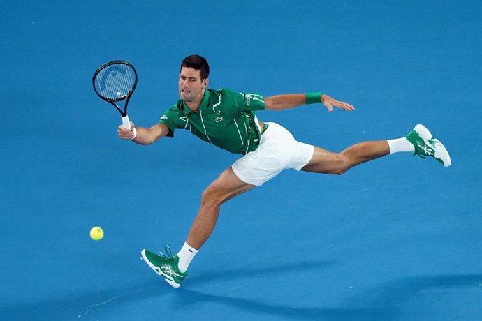 Novak Djokovic devuelve una bola en su debut en el Abierto de Australia 2020