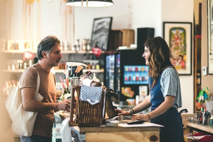 Un hombre comprando en un pequeño comercio