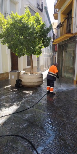 Un trabajador limpia la Calle San Isidoro de Sevilla