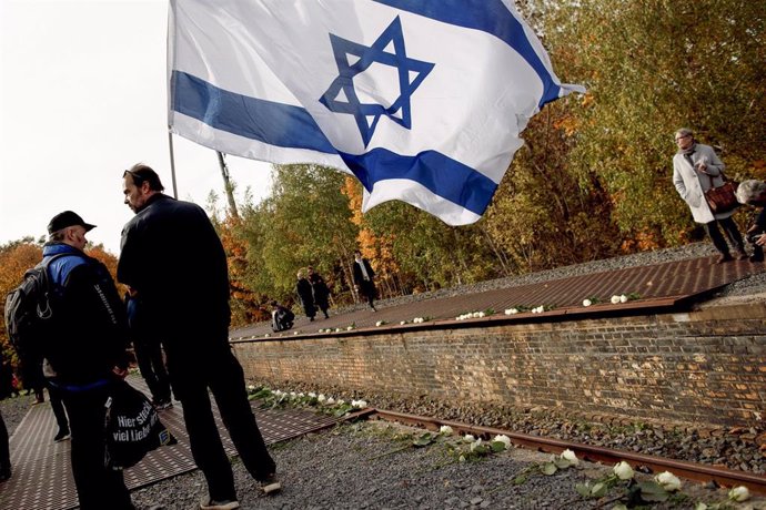 Un hombre con una bandera de Israel en conmemoración del aniversario del Holocausto.
