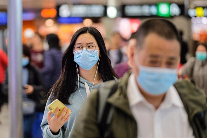 23 January 2020, China, Hong Hong: Travellers wear surgical mask at the departure hall of the West Kowloon Rail station. Hong Kong is in high alert as the coronavirus outbreak killed 17 people in China so far, travellers are being cautious and many put 