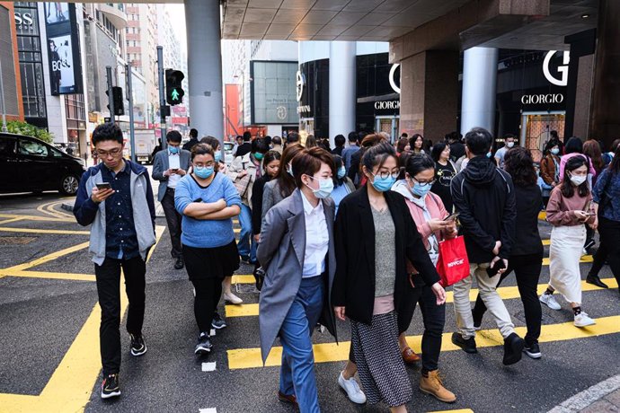 23 January 2020, China, Hong Hong: Locals wear surgical mask and cross the street during lunch hour. Hong Kong is in high alert as the coronavirus outbreak killed 17 people in China so far, travellers are being cautious and many put on surgical mask as 