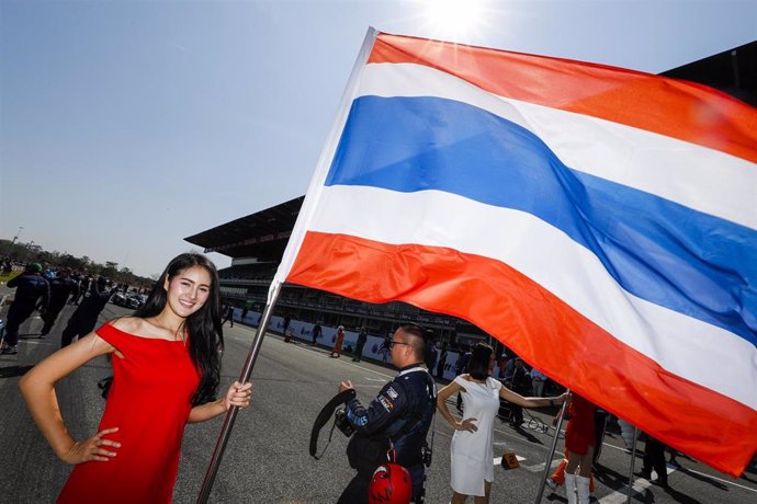 Una azafata sostiene una bandera de Tailandia en el circuito Chang International de Buriram