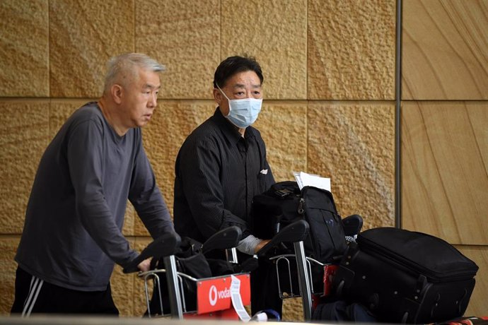 Pasajeros em el aeropuerto de Sídney se protegen del coronavirus con mascarillas. 