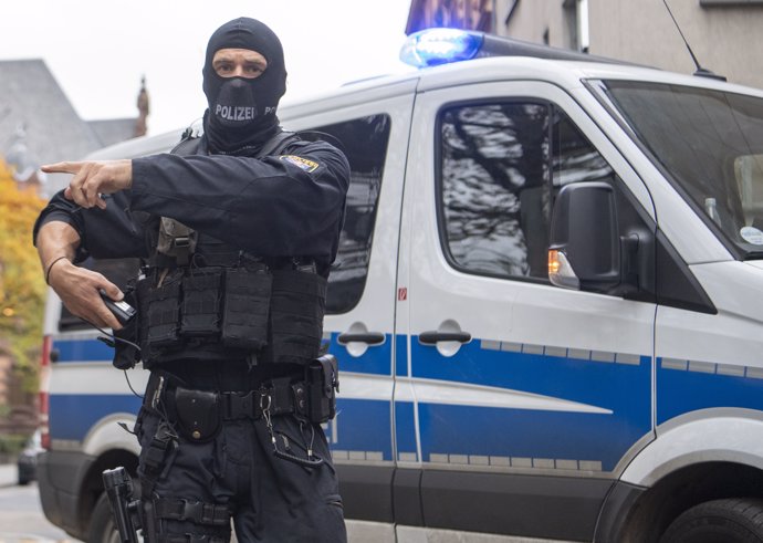 13 November 2019, Frankfurt/Main: Masked officers of a special police unit secure the evacuation of a suspected terrorist man who had previously been brought before the magistrate at the court centre. Photo: Boris Roessler/dpa