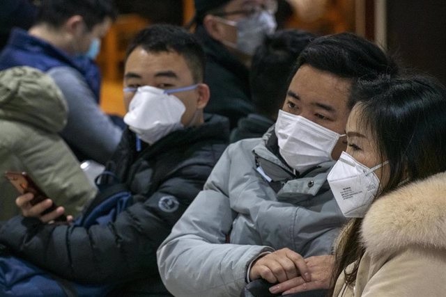 Imagen de unas personas en China con máscaras en medio del brote causado por el coronavirus. 