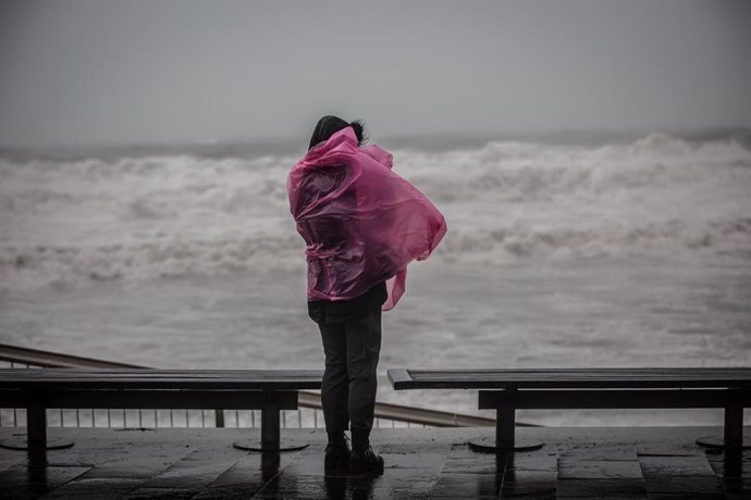 Una mujer en el paseo marítimo de Barcelona, donde la borrasca 'Gloria' ha dejada fuertes lluvias, a 21 de enero de 2020.