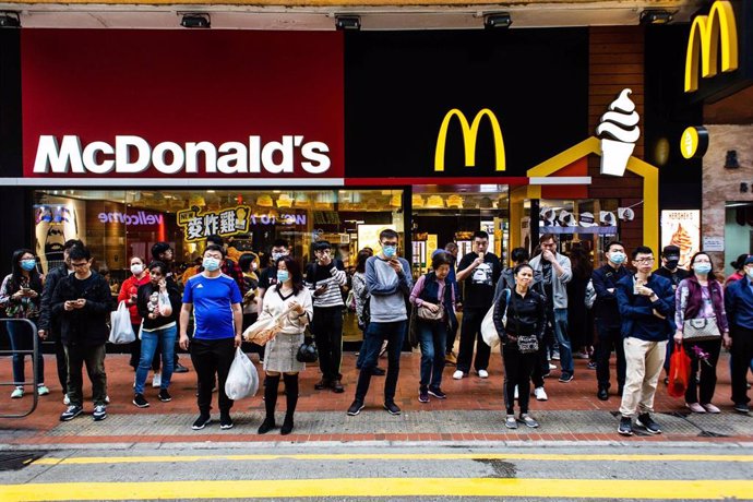 24 January 2020, China, Hong Kong: People wearing surgical masks stand in front of a McDonald's branch amid the outbreak of the coronavirus. Photo: Willie Siau/SOPA Images via ZUMA Wire/dpa