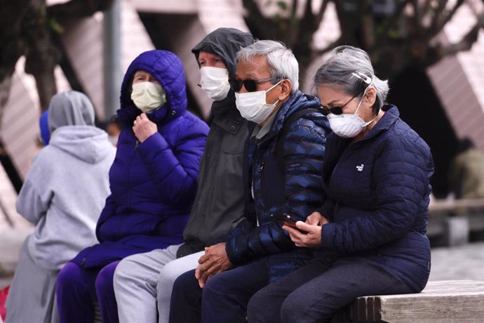 27 January 2020, China, Hong Kong: People rest on the bench while wearing surgical masks amid the outbreak of the coronavirus. Photo: Liau Chung Ren/ZUMA Wire/dpa