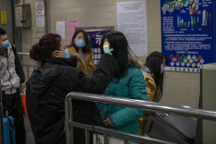 January 24, 2020 - Shanghai, China: Commuters are checked by railway staff with an electronic thermometer at South Shanghai Railway Station in wake of the coronavirus outbreak.