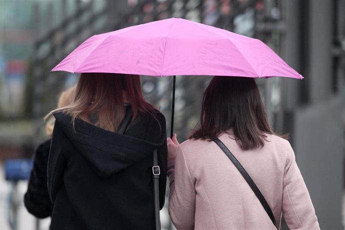 Dos mujeres pasean con paraguas para protegerse de la borrasca `Gloria que deja fuertes lluvias en la capital, en Madrid (España), a 24 de enero de 2020.