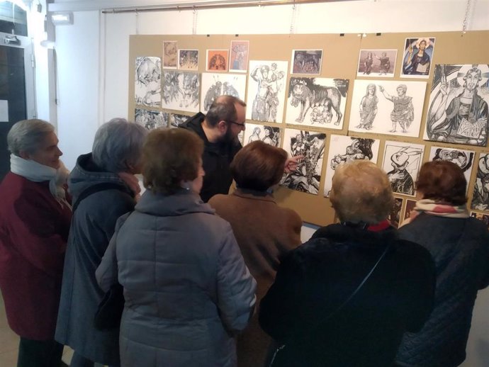 El artista, junto a varias personas que han visitado su exposición.