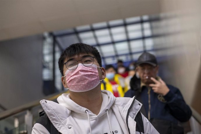 January 27, 2019 - Shanghai, China: A young man wears face masks in wake of the coronavirus outbreak as he rides an escalator to the platform from which a high speed train to Nanning, Guangxi Province, will depart. Hongqiao Railway Station was unusually