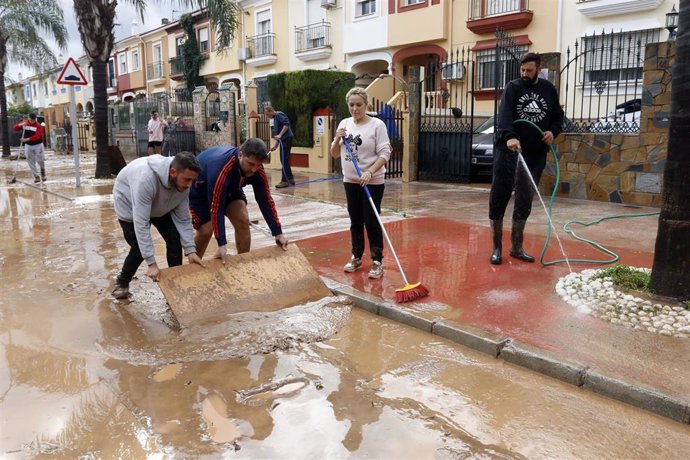 Vecinos de Campanillas limpian las calles tras la tormenta.