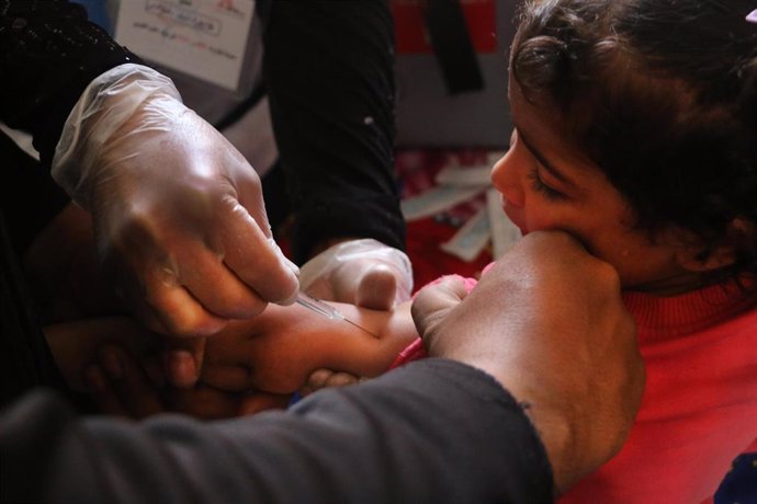 Una enfermera vacuna a una niña en Al-Atareb, Siria.