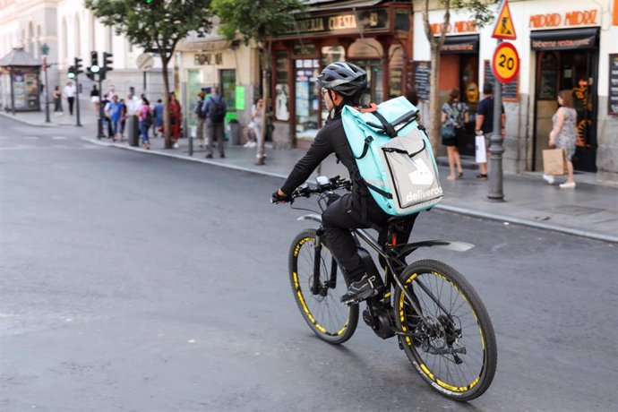 Fotografía de un repartidor de la empresa de reparto Deliveroo transitando en bicliceta por una calle del centro de Madrid.