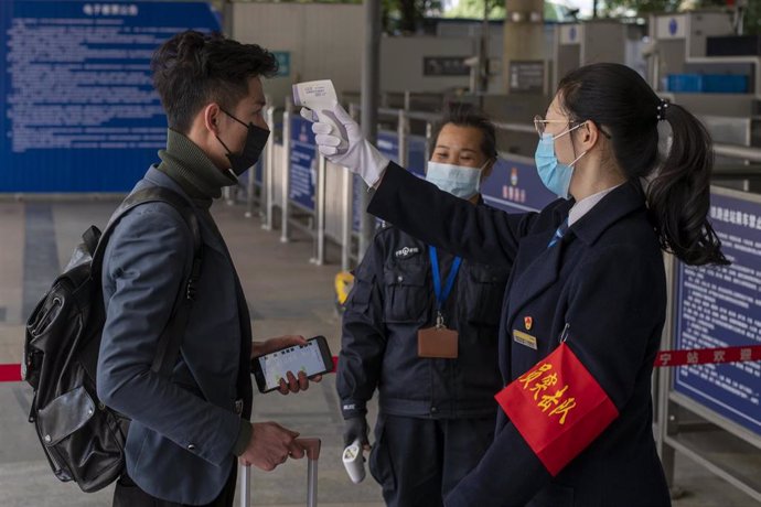 January 28, 2019, Nanning, China - A commuter's temperature is tested by security staff at Nanning Railway Station wear in wake of the coronavirus outbreak, which has five reported cases in this city of more than seven million. The entire city of Wuhan 