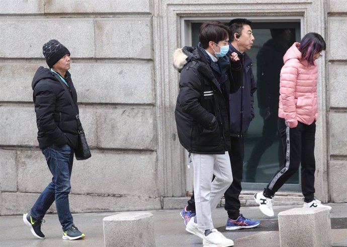 Grupo de asiáticos turistas pasean por la calle y uno de ellos lleva una mascarilla. La Organización Mundial de la Salud  (OMS) ha elevado este lunes a Alta la amenaza internacional por el Coranavirus de Wuhan, en Madrid (España), a 28 de enero de 202