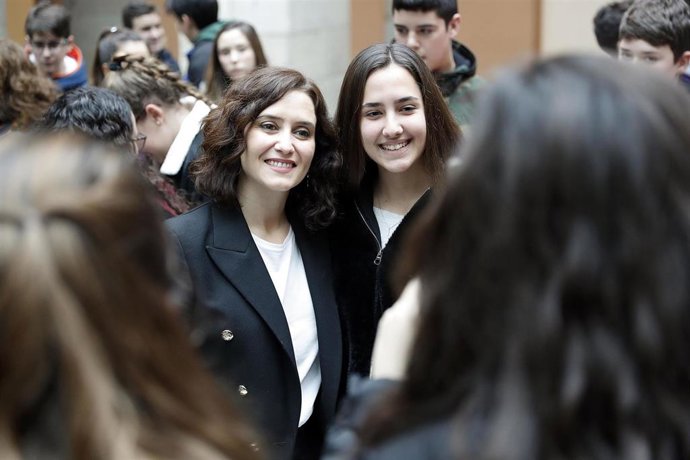 La presidenta de la Comunidad de Madrid, Isabel Díaz Ayuso, posa con una estudiante en la Real Casa de Correos donde se ha proyectado un vídeo contra el acoso escolar.