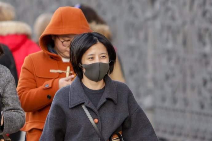 Una mujer asiática pasea con una mascarilla protectora, mientras las farmacias registran una alta demanda de estas por parte de ciudadanos chinos tras el coronavirus, en Madrid (España), a 30 de enero.