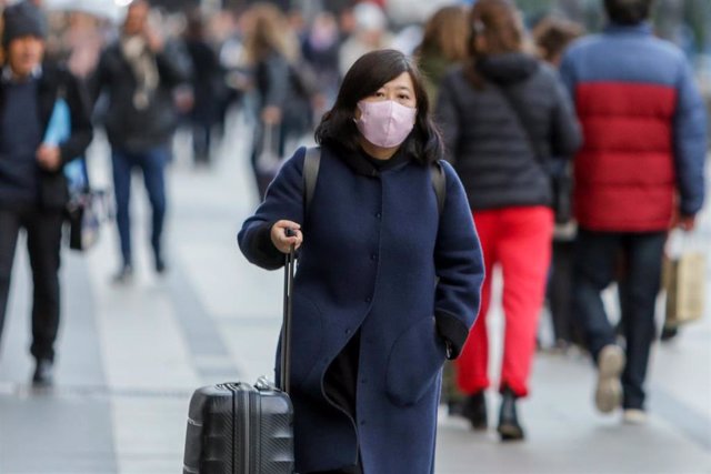 Una mujer asiática pasea con una mascarilla protectora, mientras las farmacias registran una alta demanda de estas por parte de ciudadanos chinos tras el coronavirus, en Madrid (España), a 30 de enero.