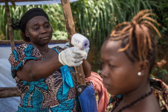 Una mujer realiza un control de detección del ébola en República Democrática del Congo con una pistola térmica