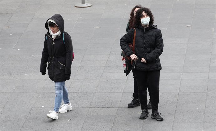 Una mujer pasea con una mascarilla protectora