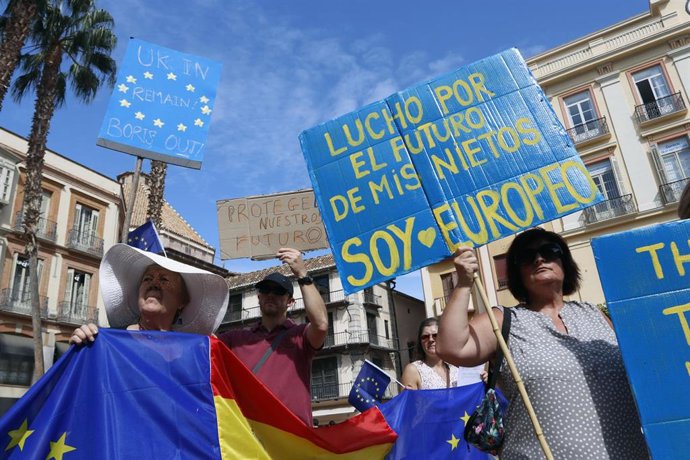 Manifestantes sujetan pancartas y banderas europeas en la plaza de La Constitución de la capital malagueña