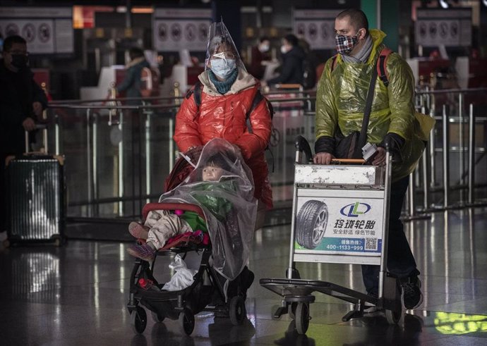 Una familia con máscaras protectoras  en el aeropuerto de Beijing, China.