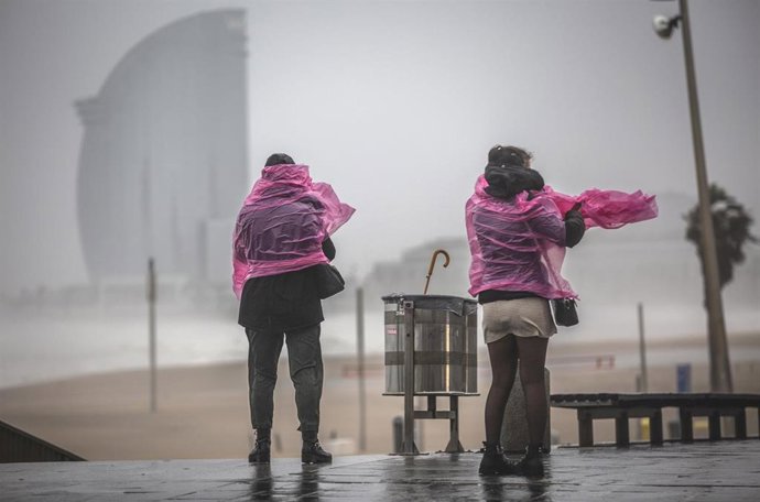 Dos mujeres en el paseo marítimo de la playa de la Barceloneta (Barcelona), durante la borrasca 'Gloria, a 21 de enero de 2020.