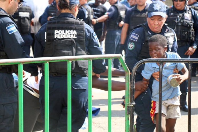 Agentes de la Policía y un niño migrante en México