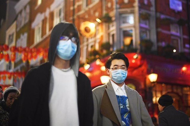 Imagen de dos personas con mascarillas en el barrio de Chinatown, en Londres.