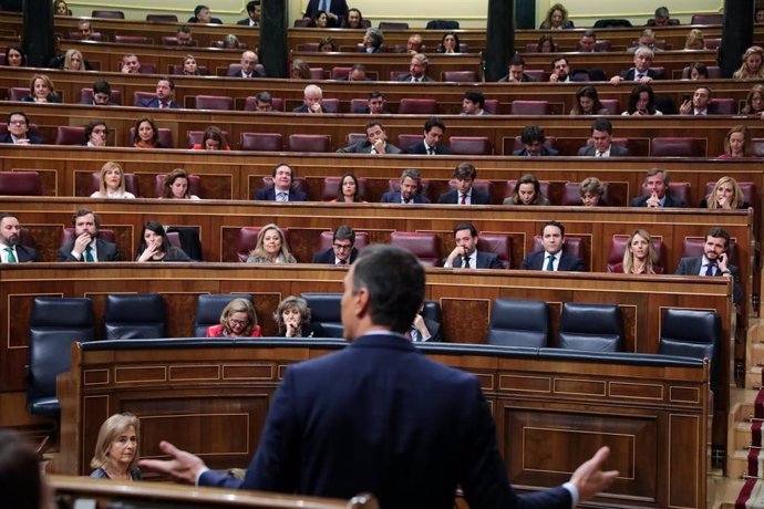 El presidente del Gobierno, Pedro Sánchez, de espaldas, comparece desde su escaño ante el Pleno del Congreso