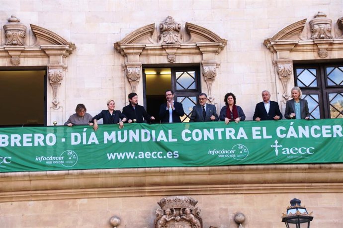 El presidente de AECC Baleares, Javier Gómez, el alcalde de Palma, José Hila, y otros regidores han colgado la pancarta de la Asociación para conmemear el Día Mundial contra el cáncer.