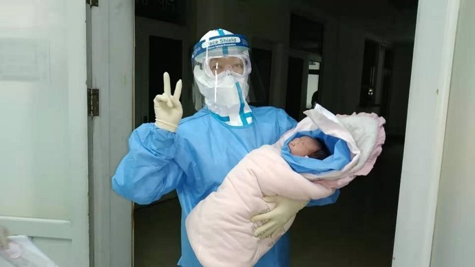 Un trabajador médico sostiene al recién nacido en el Hospital No. 6 de la ciudad de Harbin, en la provincia de Heilongjiang, al noreste de China.