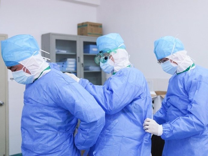 Treballadors mdics s'ajuden mútuament per posar-se vestits protectors contra el coronavirus, a la Xina, 2 de febrer del 2020.