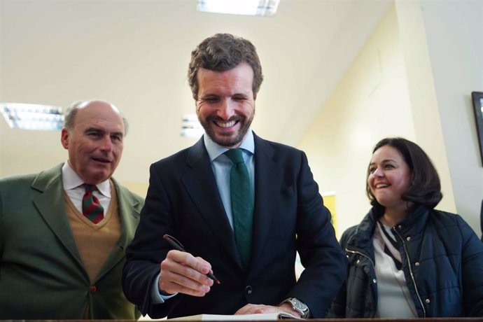 El presidente nacional del PP, Pablo Casado, durante la visita a la industria aceitera Framoliva, en Huévar del Aljarafe (Sevilla) firmando en el libro de honor de la empresa,