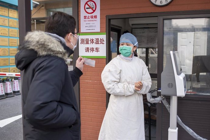 February 3, 2020 - Shanghai, China: A man shows a slip for doctors appoinment to a nurse at the entrance to Xuhui Hospital in the former French Concession. Many Shanghai residents are staying indoors to avoid contagion from the coronavirus which has rep