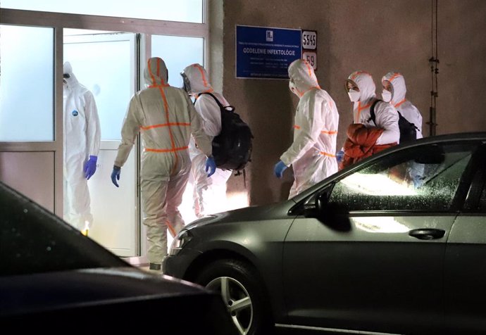 03 February 2020, Slovakia, Banska Bystrica: Medical staff wearing protective suit escort the two Slovak citizens suspected of being coronavirus after being evacuated from Wuhan, China, at F. D. Roosevelt University Hospital, where they will be quaranti