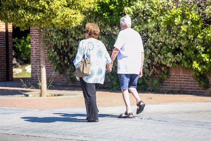 Ancianos paseando por una calle.