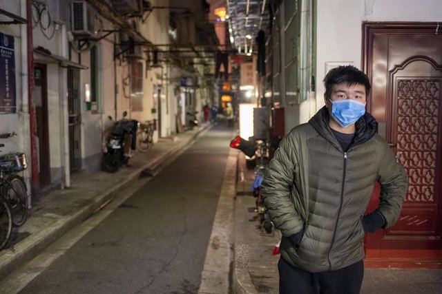 February 3, 2020 - Shanghai, China: A young man in a surgical mask at an intersection on Wufu Alley in Huangpu District. The streets of Shanghai have been unusually quiet as people stay in doors to avoide contagion from the ongoing coronavirus outbreak.