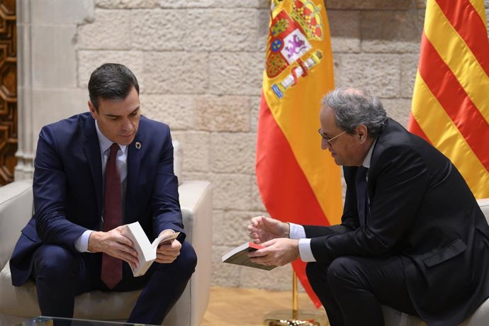 El presidente de la Generalitat, Quim Torra (dech) le regala dos libros al presidente del Gobierno, Pedro Sánchez (izq), antes de su reunión en el Palau de la Generalitat, en Barcelona /Catalunya (España), a 6 de febrero de 2020.