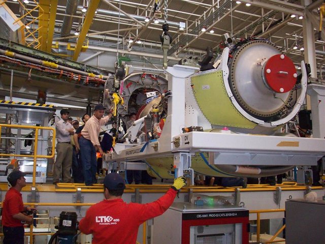Operarios de LTK dentro de la fábrica, con un motor del A400M