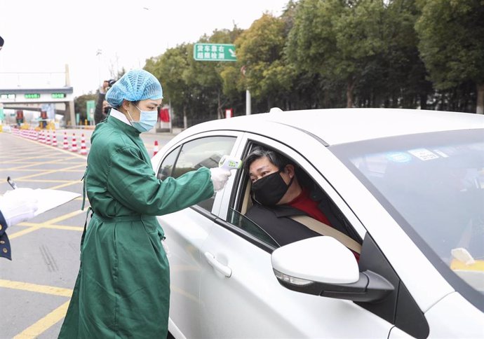 06 February 2020, China, Huaian: A doctor uses a forehead digital thermometer to measure the body temperature of a man in his car as a precautionary measure to prevent the spread of coronavirus. Photo: -/TPG via ZUMA Press/dpa