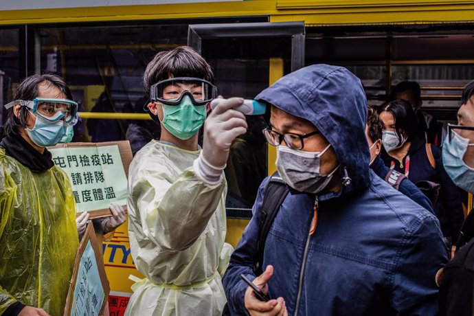 Un home mesura la temperatura a un altre a Hong Kong pel brot del nou coronavirus. 