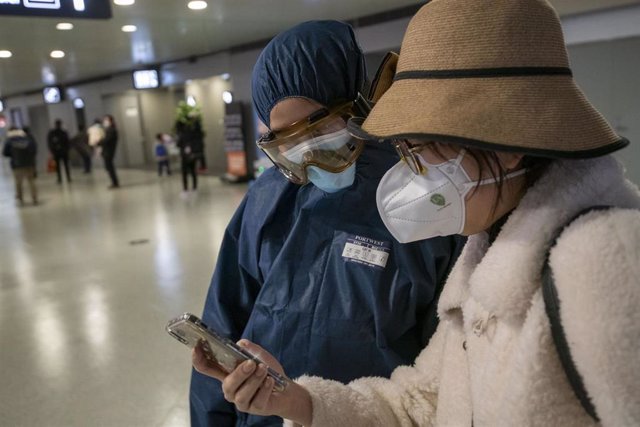 Imagen de dos personas en China con mascarillas tras el brote del nuevo coronavirus. 