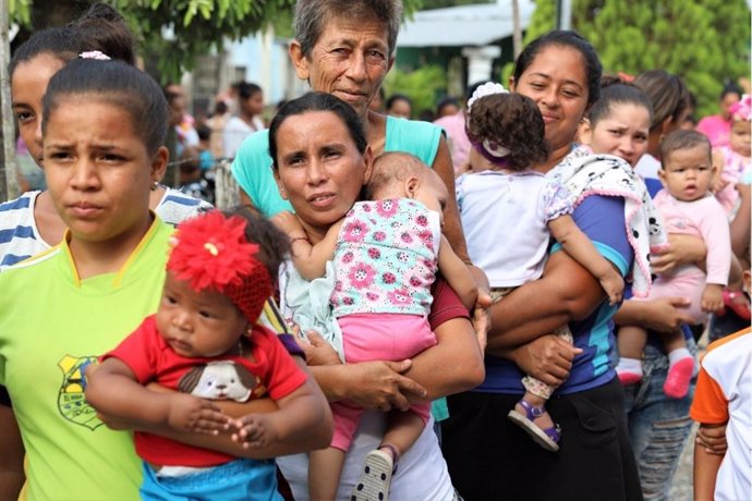 Madres con sus hijos esperan a recibir atención en Venezuela
